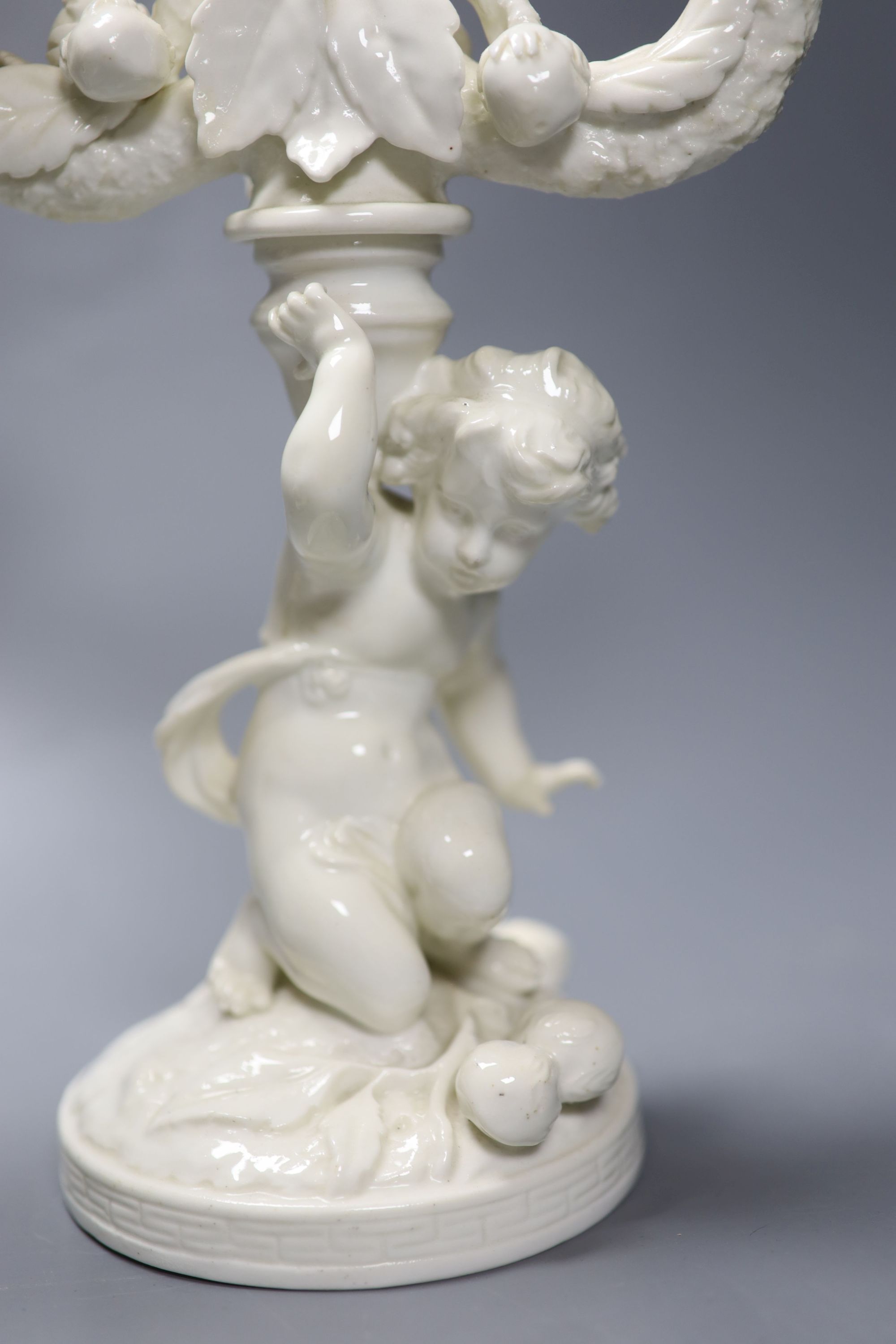 A pair of English bone china cherub candelabra, possibly Moore Bros., height 26cm